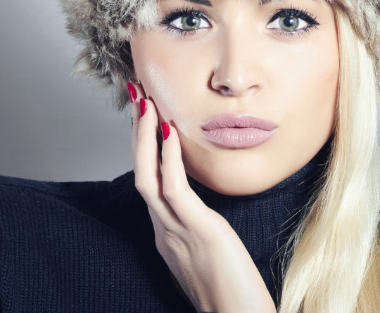 Close-up Beautiful Blond Woman in Fur Cap. Beauty Girl. Winter
